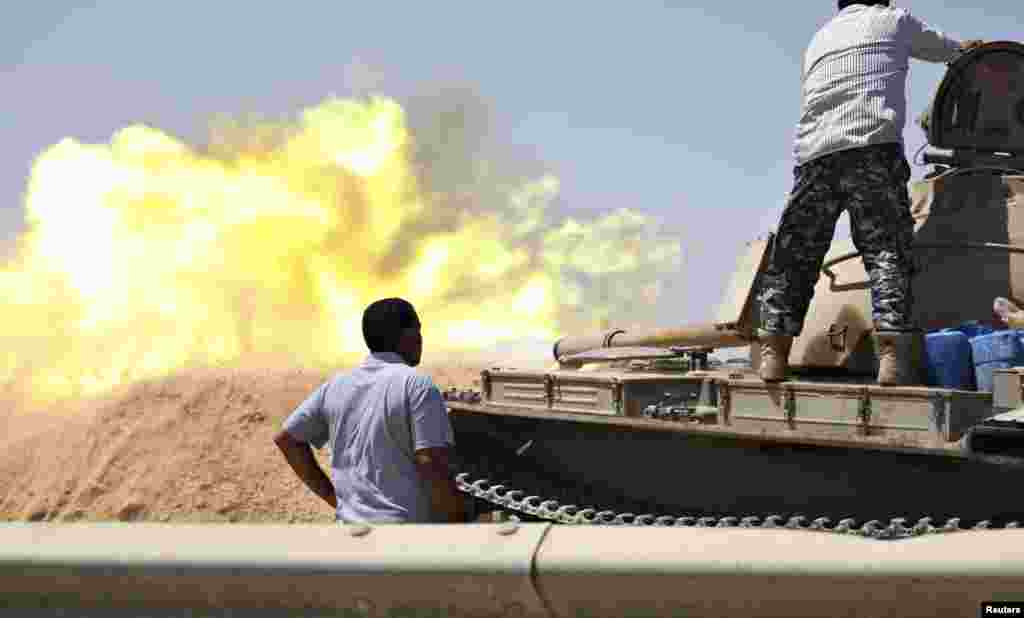 Liviya Mudofaa kuchlariga qarashli tank muxolif jangari guruhlar bilan bo'lib o'tgan to'qnashuvda o't ochmoqda, Tripoli, Liviya, 22-avgust, 2014-yil.