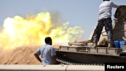 A tank belonging to the Western Shield, a branch of the Libya Shield forces, fires during a clash with rival militias around the former Libyan army camp, Camp 27, in the 27 district, west of Tripoli, Aug. 22, 2014.
