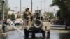 مامور امنیتی افغانستانی در حال ترک صحنه انفجار یک بمب کنار جاده در شهر کابل افغانستان - ۴ ژوئن ۲۰۲۱