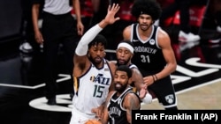 Derrick Favors (15) du Utah Jazz tente de bloquer Kyrie Irving (11) des Brooklyn Nets lors du match du 5 janvier 2021.