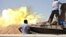A tank belonging to the Western Shield, a branch of the Libya Shield forces, fires during a clash with rival militias around the former Libyan army camp, Camp 27, in the 27 district, west of Tripoli, Aug. 22, 2014.