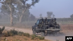 FILE - Members of the Cameroonian Rapid Intervention Force patrol, March 21, 2019, on the outskirt of Mosogo in the far north region of the country where Boko Haram jihadist have been active since 2013.