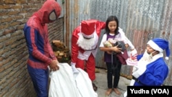 Dua orang muslim berbusana sinterklas dan superhero spiderman berbagi bingkisan Natal untuk anak-anak jemaat Gereja di Solo, Selasa (24/12). Foto : VOA/Yudha Satriawan