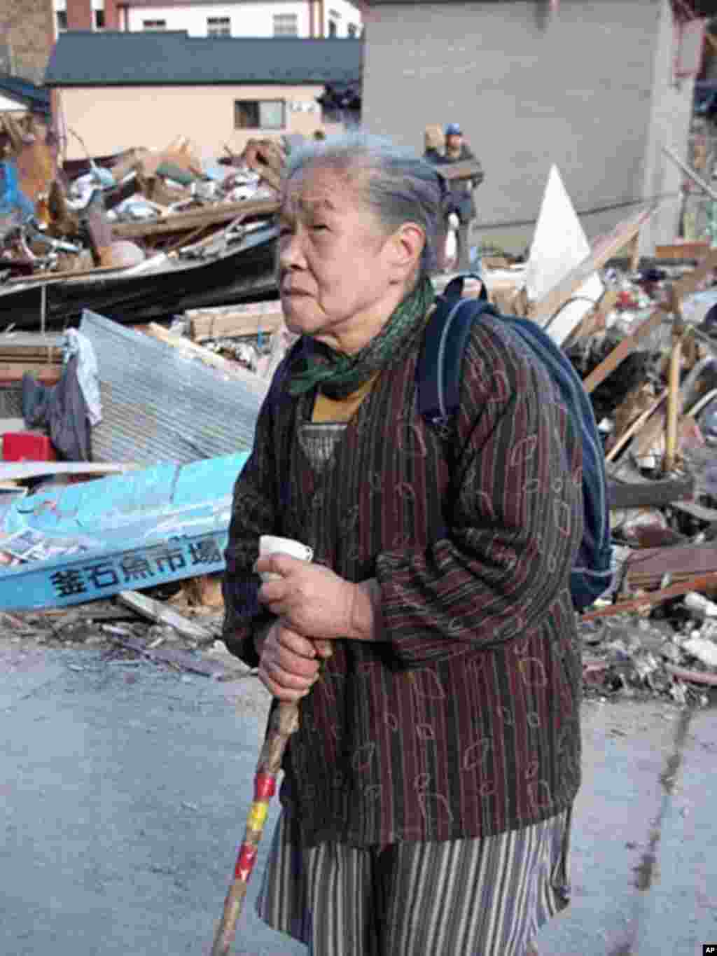84-year-old Ayako Ito wanders amid the ruins of her hometown, Kamaishi, Japan, March 17, 2011 (VOA - H. Ridgwell)
