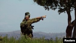 FILE - Israeli soldiers observe the Syrian side of the Quneitra border crossing between the Israeli-controlled Golan Heights and Syria, August 29, 2014. 