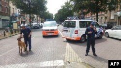 A picture taken with a smartphone on June 17, 2016 shows Belgian police officers standing guard in the Kazernelaan - Avenue des Casernes, in the district of Etterbeek, in Brussels, where terrorists Osama Krayem and Khalid El Bakraoui lived before the atta