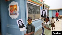 Anak-anak membawa foto Kamala Harris, cawapres terpilih AS, di sebuah kuil di Thulasendrapuram, di negara bagian Tamil Nadu, Minggu, 8 November 2020. (Foto: Reuters)