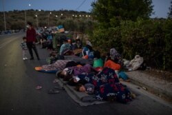 Migrants sleep on the road near the Moria refugee camp on the northeastern island of Lesbos, Greece, Sept. 10, 2020.