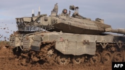 Un convoy de vehículos blindados israelíes rueda en un campo después de regresar de la Franja de Gaza el 15 de enero de 2024, en medio de las batallas en curso entre Israel y el grupo militante palestino Hamás.