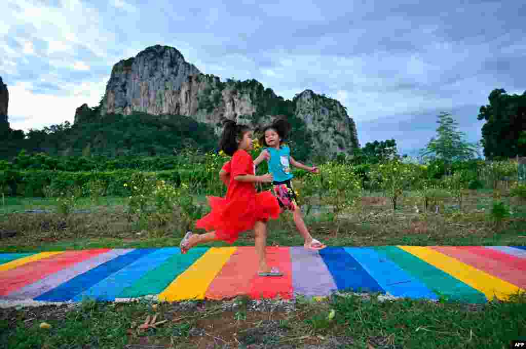 태국 카오치칸(Khao Chakan) 휴양지 근방에 무지개색으로 칠한 길 위로 아이들이 뛰어가고 있다.