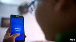 Một người đàn ông đang lướt mạng xã hội Facebook tại một quán cà phê ở Hà Nội ngày 28/11/2013. Cục Báo chí của Bộ Thông tin và Truyền thông Việt Nam mới đây yêu cầu các cơ quan báo chí tăng cường quản lý nội dung trên các trang Facebook của họ.