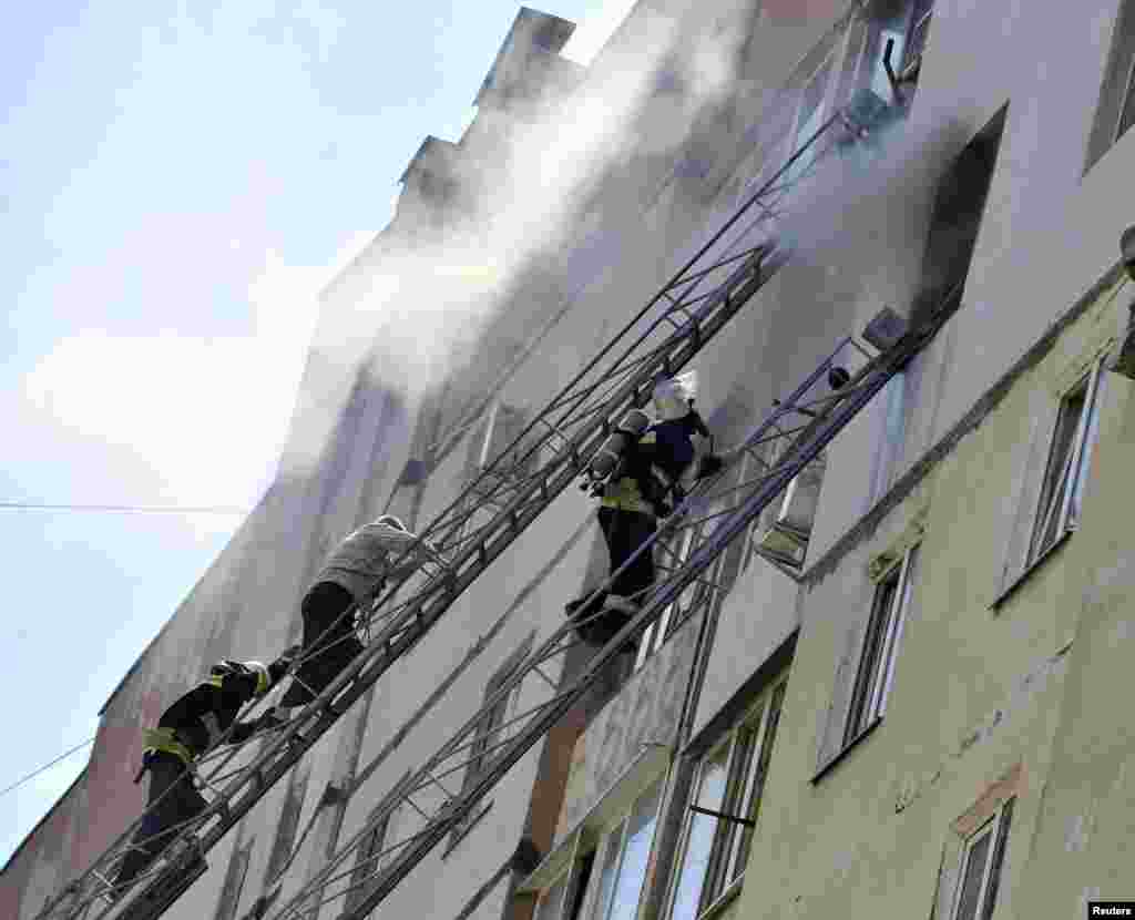 Firefighters work outside a multistory apartment block that was heavily damaged by an explosion. At least three people died in the explosion, in Mykolaiv, southern Ukraine, May 12, 2014.