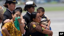 Familiares de los soldados que murieron en enfrentamientos con presuntos narcotraficantes observan cómo llegan los ataúdes en un avión a una base de la fuerza aérea en la ciudad de Guatemala, el jueves 5 de septiembre de 2019.