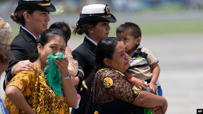 Familiares de los soldados que murieron en enfrentamientos con presuntos narcotraficantes observan cómo llegan los ataúdes en un avión a una base de la fuerza aérea en la ciudad de Guatemala, el jueves 5 de septiembre de 2019.