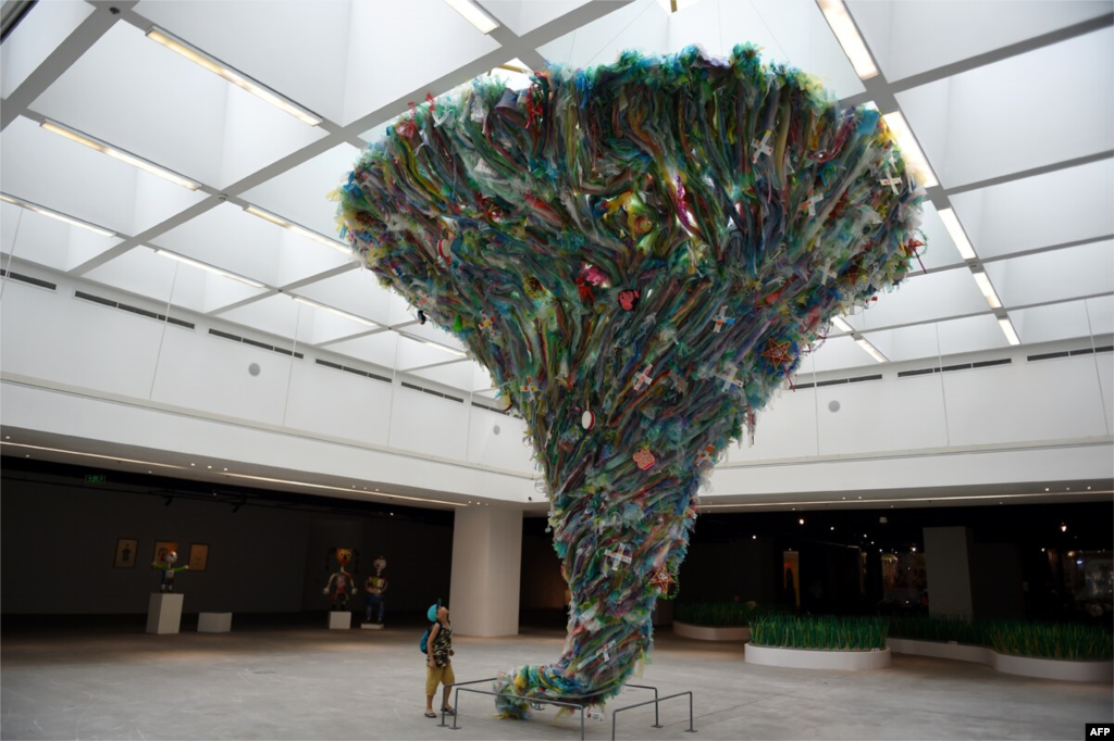 A boy looks up at the installation entitled &#39;Tornado by plastic waste&#39; by artists from the social enterprise To He at the exhibition &#39;Plastics Planet&#39; in Hanoi, Vietnam. (Nhac NGUYEN)