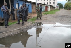 FILE - Burundian police and soldiers guard a deserted street in Bujumbura, Burundi, Nov. 8, 2015. Rising violence in Burundi is sparking calls for greater international attention.