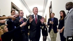 Senate Finance Committee Chairman Sen. Max Baucus, fends off reporters as he arrives to meet in the Capitol Hill office of Sen. John Kerry, and other Supercommittee members in Washington, Nov. 21, 2011