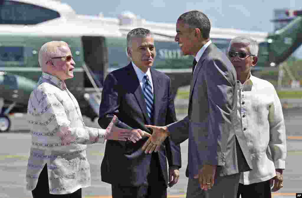 Presiden AS Barack Obama berjabat tangan dengan Menteri Pertahanan Nasional Filipina Voltaire Gazmin saat tiba di Bandar Udara Internasional Ninoy Aquino di Manila (17/11). (AP/Susan Walsh)