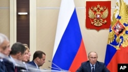 file - Russian President Vladimir Putin, right, presides over a cabinet meeting at the Novo-Ogaryovo residence outside Moscow, Russia.