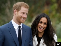 FILE - Britain's Prince Harry and his fiancee, Meghan Markle, pose for photographers in the grounds of Kensington Palace in London, Nov. 27, 2017.