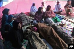 Family members gather around the bodies of earthquake victims in Pidie Jaya, Aceh province, Indonesia, Dec. 7, 2016.