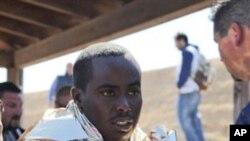 A man receives assistance upon his arrival in Lampedusa, southern Italy, Wednesday, April 6, 2011. Italian coast guard officials were trying Wednesday to rescue migrants lost at sea after their boat capsized.