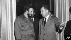 Le Premier ministre cubain Fidel Castro se fait accompagner du vice-président américain Richard Nixon au sortir d’une visite au bureau de ce dernier à Washington, D.C., le 19 avril 1959.