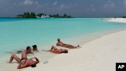 资料照片：游客在马尔代夫马累环礁的天堂岛海滩享受日光。(2012年2月14日)