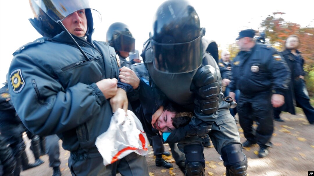 Polisi anti huru-hara menahan satu pemrotes anti-gay dalam rapat umum LGBT di St. Petersburg, Rusia (12/10).