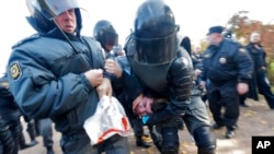 Polisi anti huru-hara menahan satu pemrotes anti-gay dalam rapat umum LGBT di St. Petersburg, Rusia (12/10).