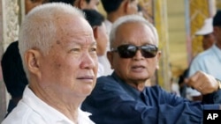 FILE - Former Khmer Rouge leaders Khieu Samphan, left, and Nuon Chea sit together during funeral services for the first wife of Khmer Rouge leader Pol Pot, July 3, 2003. The two were convicted Friday of war crimes.
