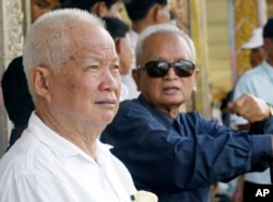 FILE - Former Khmer Rouge leaders Khieu Samphan, left, and Nuon Chea sit together during funeral services for Khieu Ponnary, the first wife of Khmer Rouge leader Pol Pot, in the former Khmer Rouge stronghold of Pailin, northwestern Cambodia, July 3, 2003.
