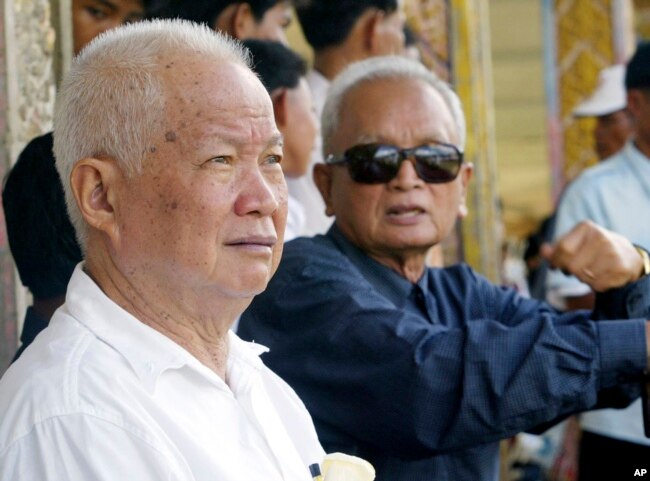 FILE - Former Khmer Rouge leaders Khieu Samphan, left, and Nuon Chea sit together during funeral services for Khieu Ponnary, the first wife of Khmer Rouge leader Pol Pot, in the former Khmer Rouge stronghold of Pailin, northwestern Cambodia, July 3, 2003.