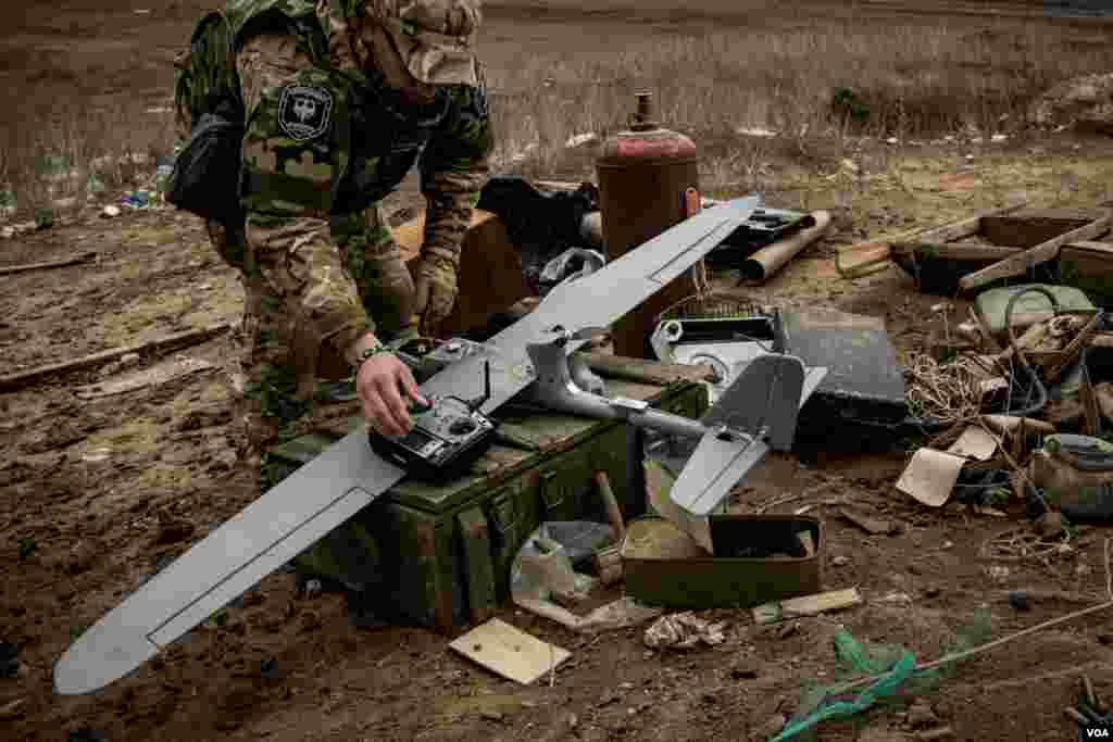 A pro-government militiaman makes preflight checks before a drone reconnaissance mission into rebel-held territory. (Adam Bailes/VOA)