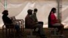 People wait to receive a dose of a COVID-19 vaccine at a center, in Soweto, Nov. 29, 2021. 