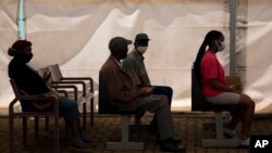 People wait to receive a dose of a COVID-19 vaccine at a center, in Soweto, Nov. 29, 2021. 