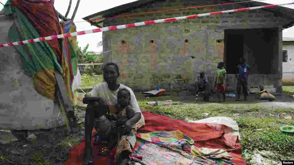 James Flomo, porteur présumé du virus Ebola, est placé en isolement avec ses enfants après le décès, trois jours plutôt, de son épouse Lorpu Flomo à Monrovia, au Libéria, 21 Janvier, 2015. REUTERS / James Giahyue
