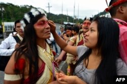 A Waorani indigenous woman gets makeup on during a demonstration against the exploitation of oil in their territory in Puyo, Ecuador, April 11, 2019.