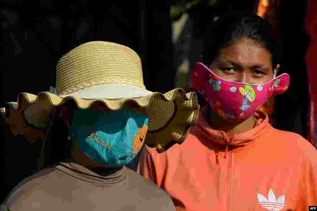 کمبوڈیا میں کی خواتین کرونا وائرس سے بچنے کے لیے تیز رنگوں والے مفرد ماسک استعمال کر رہی ہیں۔