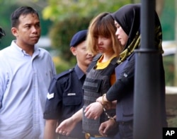 Vietnamese suspect Doan Thi Huong (second from right) is escorted by police officers from court in Sepang, Malaysia, March 1, 2017. Two young women accused of smearing VX nerve agent on Kim Jong Nam, the estranged half brother of North Korea's leader, were charged with murder.