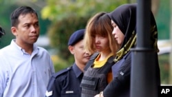 Vietnamese suspect Doan Thi Huong (second from right) is escorted by police officers from court in Sepang, Malaysia, March 1, 2017. Two young women accused of smearing VX nerve agent on Kim Jong Nam, the estranged half brother of North Korea's leader, were charged with murder.