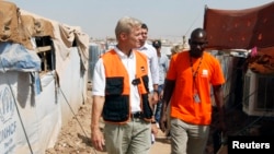 FILE - The secretary-general of the Norwegian Refugee Council (NRC), Jan Egeland (front) visits Domiz camp in the northern Iraqi province of Dohuk, Aug. 21, 2013. 