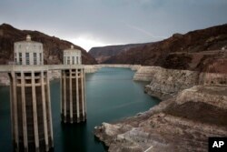 FILE - In this July 28, 2014, photo, lightning strikes over Lake Mead near Hoover Dam at the Lake Mead National Recreation Area in Arizona. For Arizona and Nevada, the reservoir on the Colorado River is a major source of drinking water.