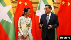 18일 중국을 방문한 미얀마의 아웅산수치 국가자문역 겸 외무장관(왼쪽)이 리커창 중국 총리와 양국간 협정 조인식에서 대화하고 있다.