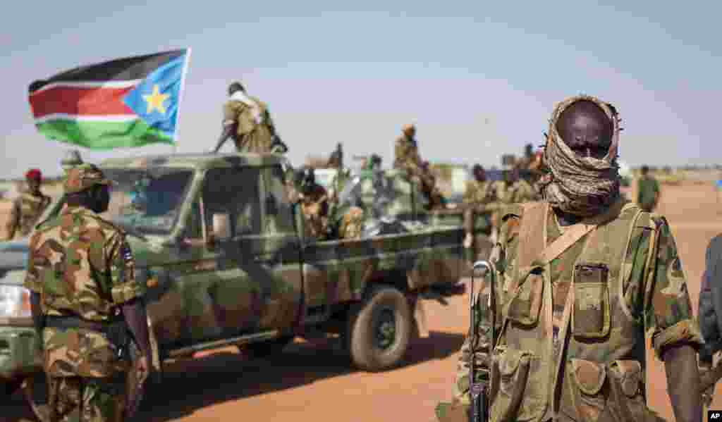 A South Sudanese government soldier stands with others near their vehicles, after government forces retook Bentiu, capital of Unity State, from opposition fighters on Jan. 10.