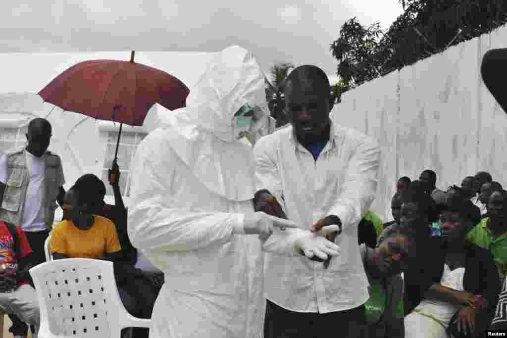 Seorang relawan medis berlatih menggunakan pakaian yang dilengkapi dengan&nbsp;alat pengamanan pribadi&nbsp;(PPE) di pusat layanan medis untuk penanggulangan Ebola yang baru dibangun di Monrovia, Liberia (21/9). 