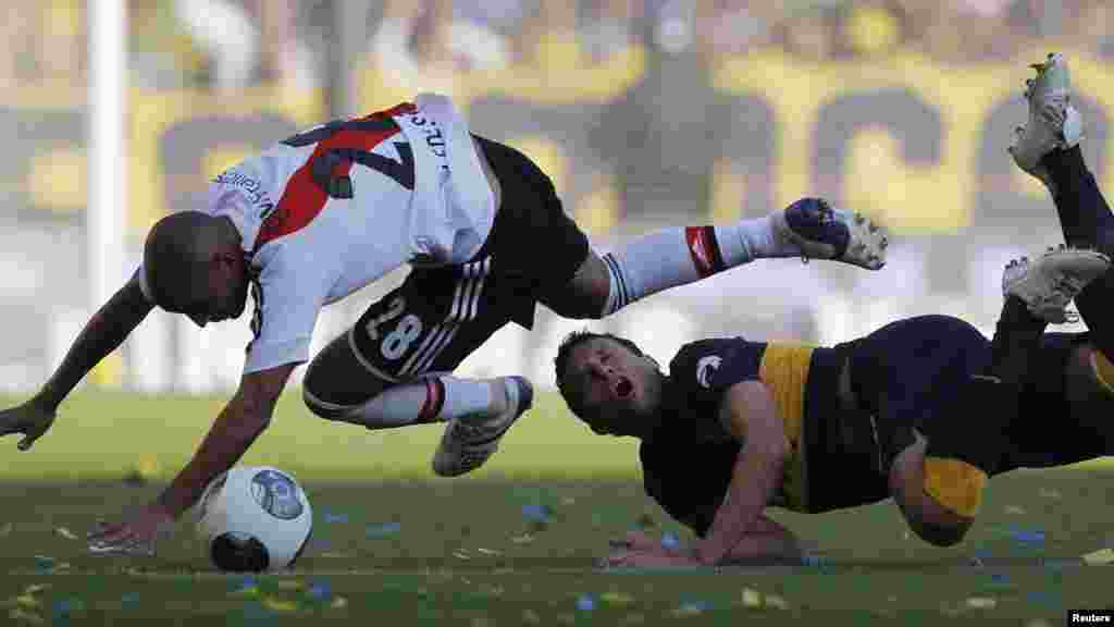 River Plate's Cristian Ledesma (L) and Boca Juniors' Pablo Ledesma crash as they fight for the ball during their Argentine First Division soccer match in Buenos Aires May 5, 2013.
