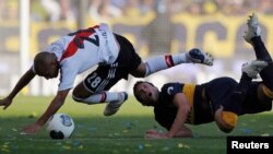 Pablo Ledesma, joueur de Boca Juniors, à droite, et Cristian Ledesma de River Plate, à droite, en plein duel pour contrôle du ballon au cours d’un match première division de football, à Buenos Aires, Argentine, 5 mai 2013. REUTERS / Marcos Brindicci (ARGENTINE - Tags: IMAGES SPORT SOCCER TPX DE LA JOUR) - RTXZBX5