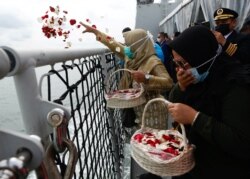 Keluarga penumpang Sriwijaya Air penerbangan SJ 182 yang jatuh ke laut, menabur bunga dari geladak kapal TNI Angkatan Laut KRI Semarang, di lokasi jatuhnya pesawat tersebut, 22 Januari 2021.