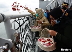 Anggota keluarga penumpang Sriwijaya Air penerbangan SJ 182 yang jatuh ke laut menaburkan bunga dari dek kapal TNI Angkatan Laut KRI Semarang saat mengunjungi lokasi jatuhnya pesawat untuk memberikan penghormatan, di laut, 22 Januari 2021.